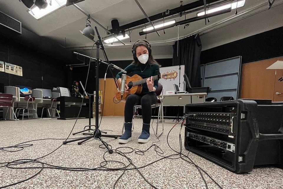 Sarah Libov, a 49图库澳门资料大全 student, plays guitar in a recording studio