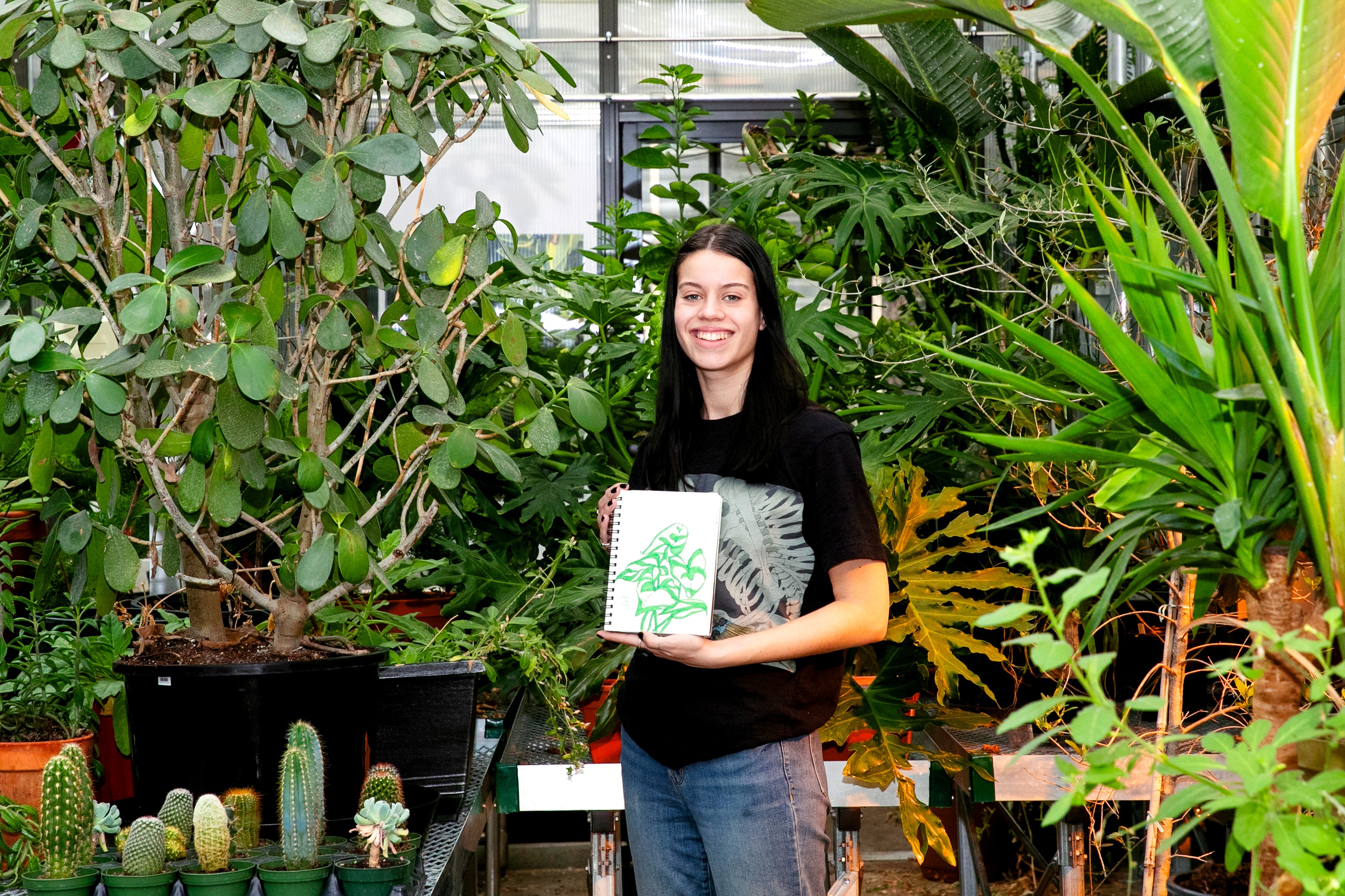 Biology and studio art double major Allison Conwell 鈥�25, who plans to pursue a career in scientific illustration, shows one of her illustrations during a visit to the Billie Tisch Center for Integrated Sciences greenhouse.
