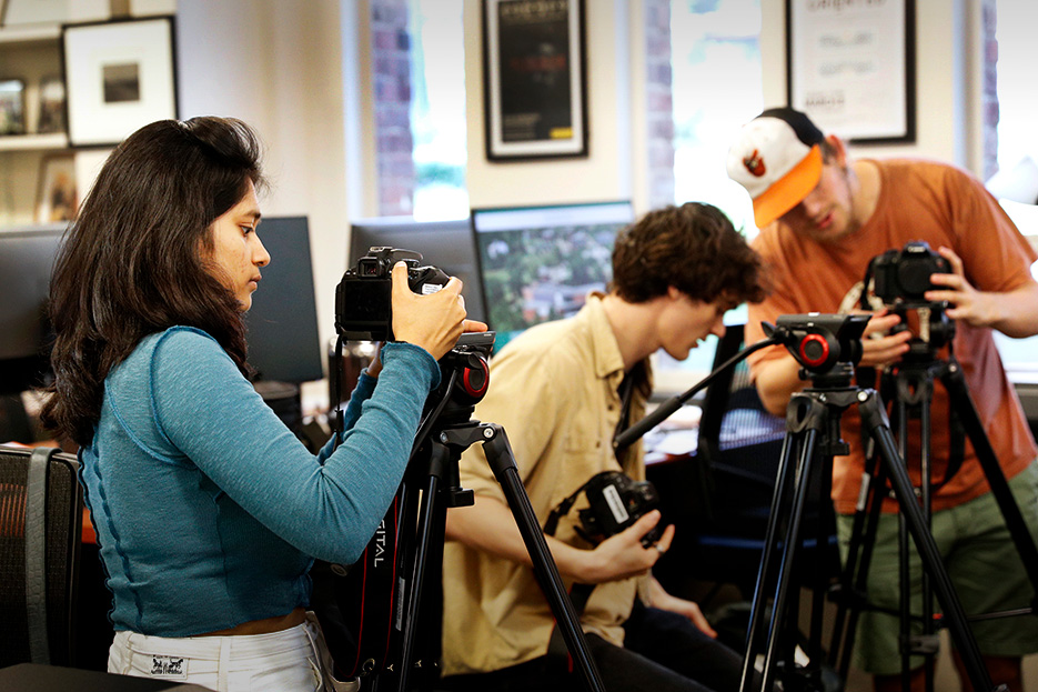 Three students work in the DOCLab with camera equipment during a documentary studies course in fall 2022.